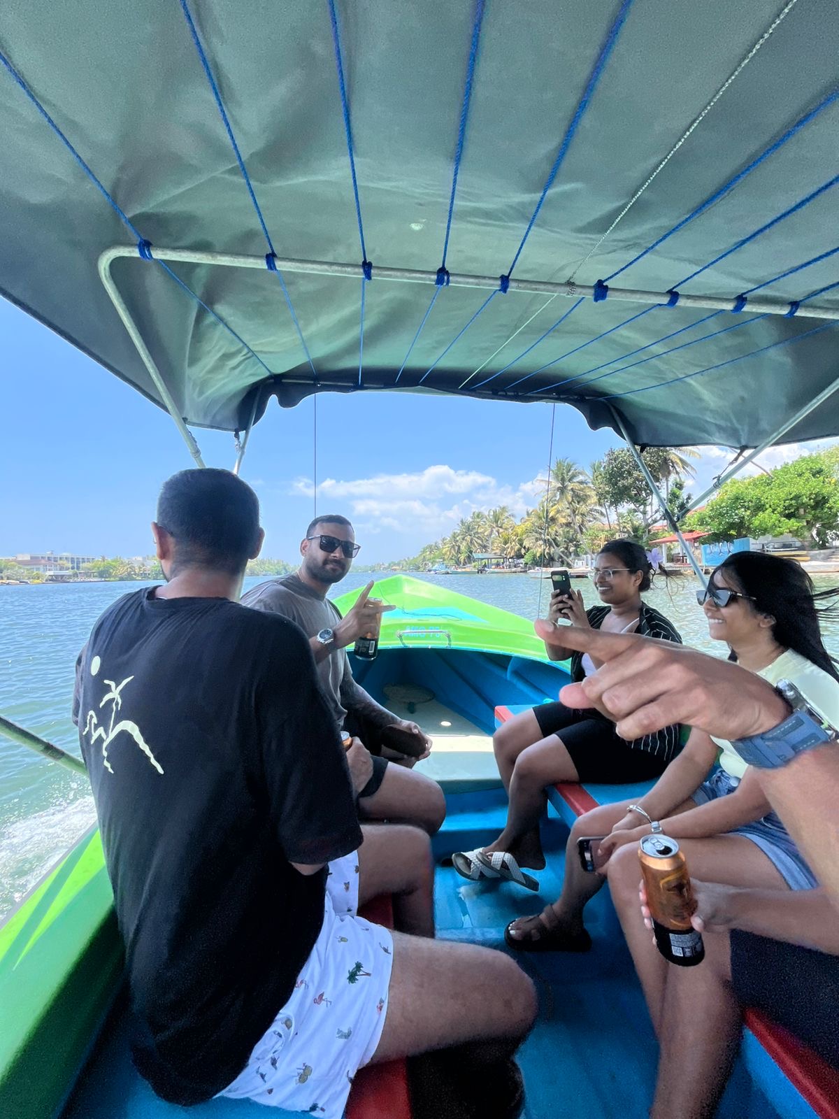 Guests chatting under the canopy of a safari boat as it cruises the Bentota River