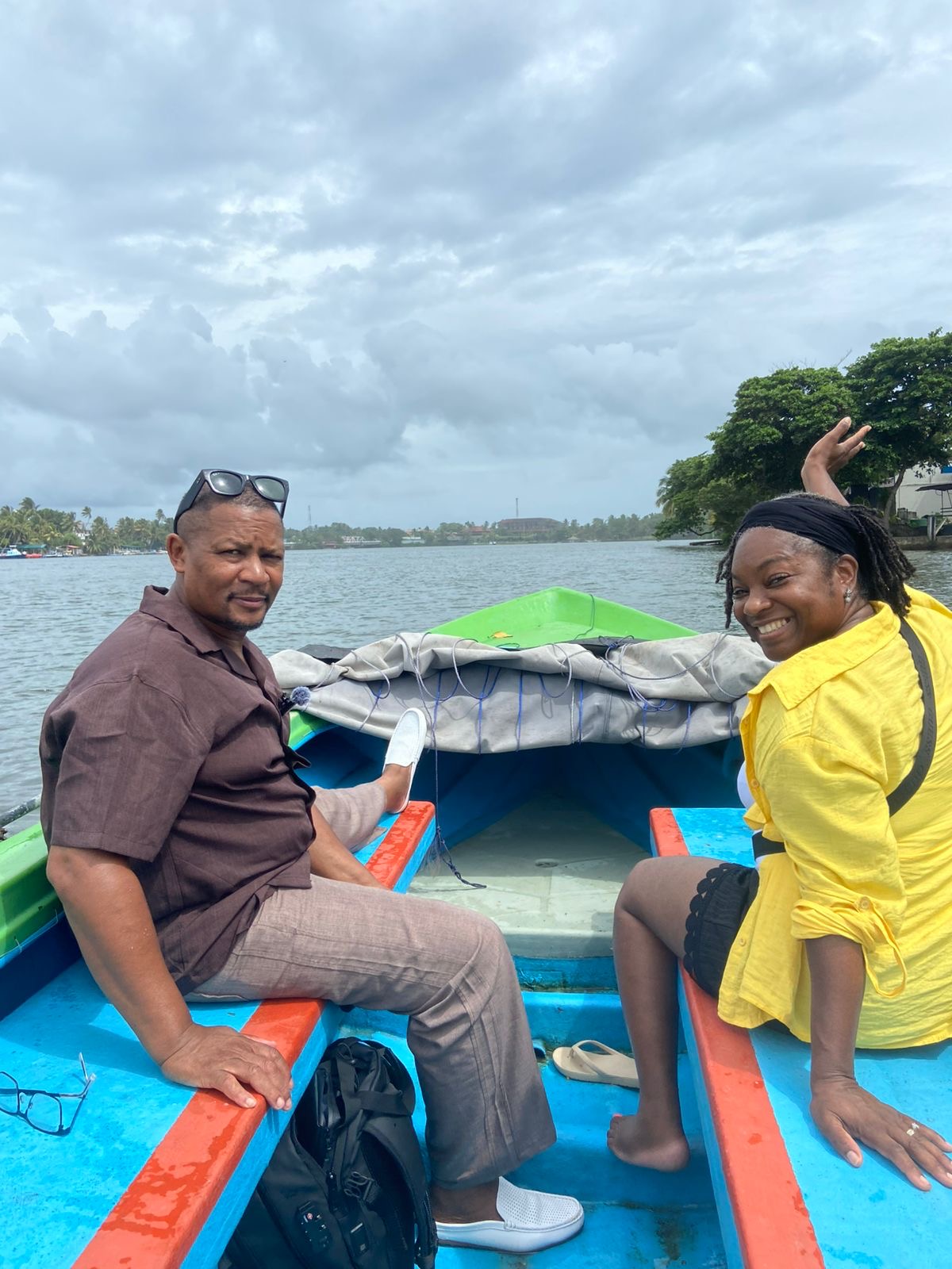 A smiling couple sitting in a brightly painted safari boat on the open river